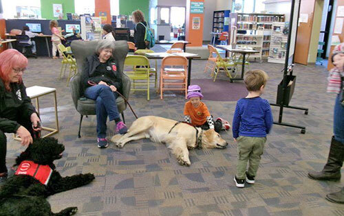 Children pet two therapy dogs in the Walla Walla Public Library