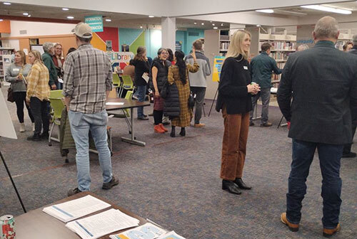 People converse and view informational displays in the library
