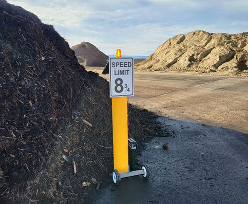 Sign on a yellow post, with text that reads 'Speed Limit 8 3/4'