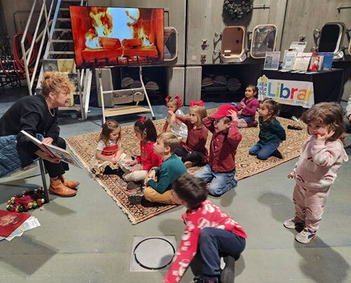 A librarian reads to a group of children in a room at a winery