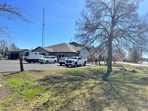 Workers stand in the front yard of Fire Station 2 while doing landscaping work