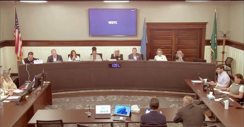 14 people — members of the transportation commission, support staff, and presenters — sit at tables and the City Council dais arranged in a rectangle