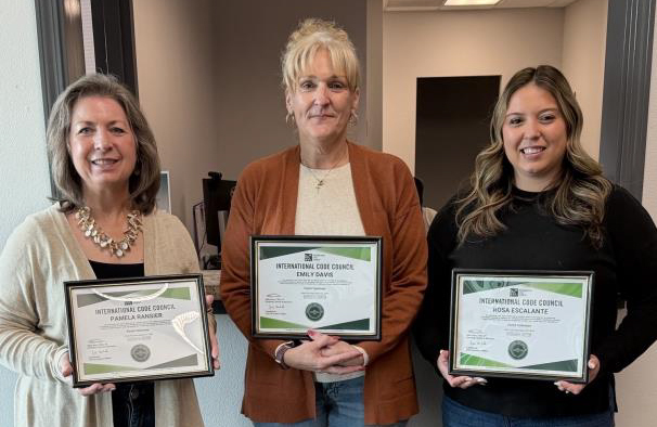 Three people hold certificates