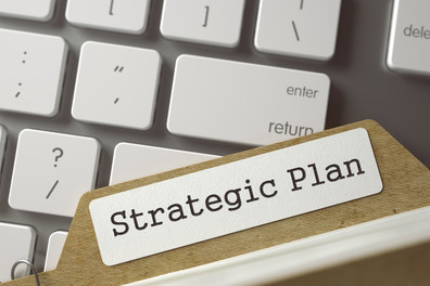 Strategic plan file placed on computer keyboard. 
