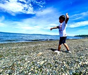 Boy skipping rocks in ocean