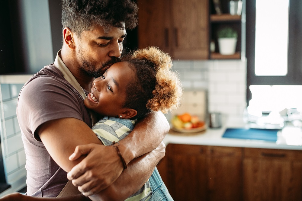 Father and daughter embrace for a hug. 