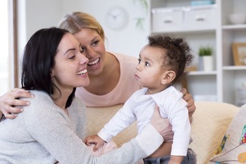 Two smiling providers attend to a baby