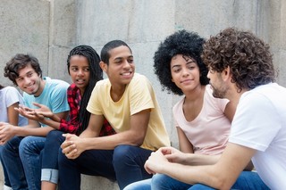 A group of youth sit outside talking. 