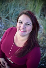 photo of Danielle smiling wearing a red shirt with red highlights in hair