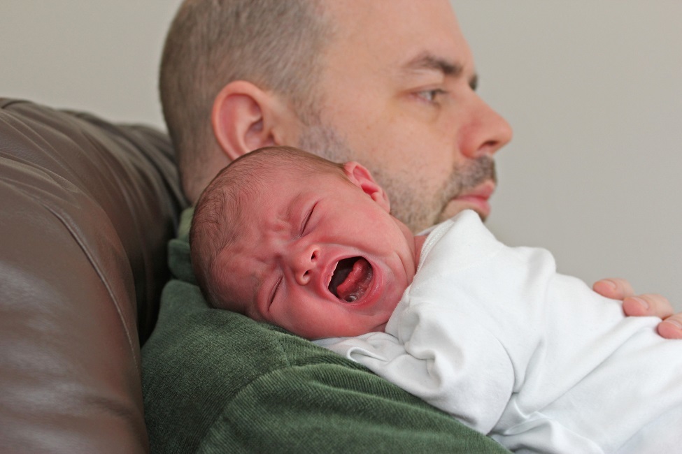 Father holding crying infant