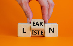 Hand displays blocks that spell "listen" and "learn." 