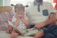 Adult reads to interested toddler