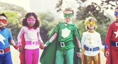 4 kids holding hands dressed up as super heroes