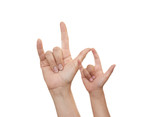 Photo of an adult and child both making the American Sign Language ‘I love you’ sign