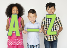 children holding up signs that say a-z