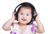 Photo of a toddler smiles at the camera, wearing oversized headphones.
