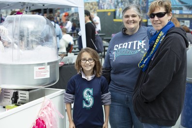 A young person and their family wearing Seattle Mariners gear. 