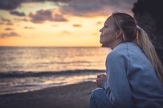 A girl smiling hopefully on a beach