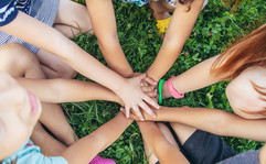 A group of children's hands coming together in unity. 