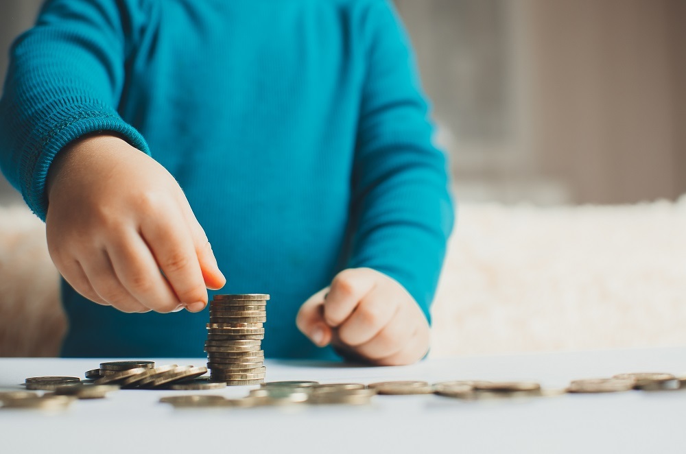 Child hands stacking coins