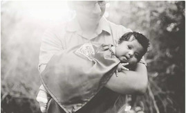 baby with down syndrome wearing a superhero cape with his dad