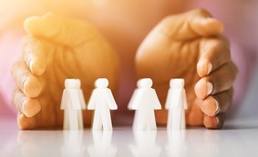 Hands protecting human-shaped figurines