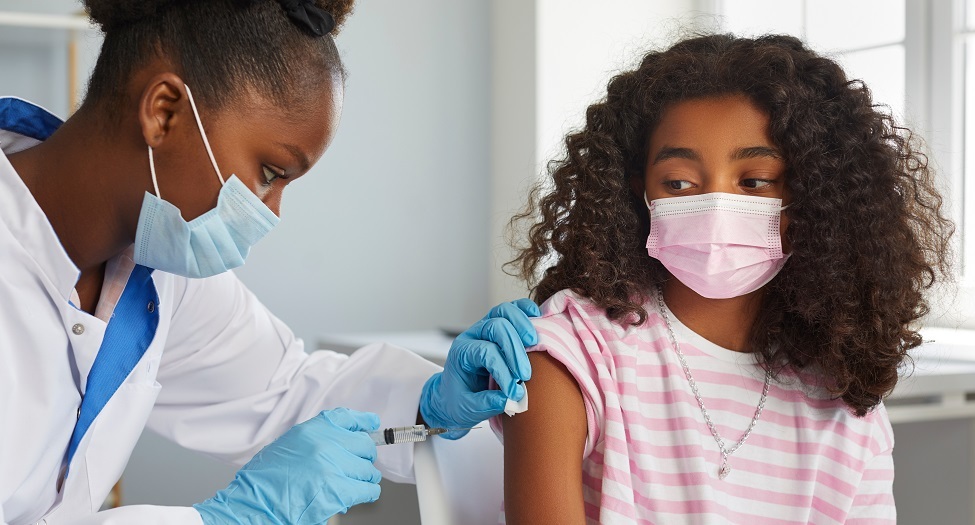 Young woman receiving vaccine from another woman nurse