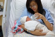 A mother bottle-feeding her infant.