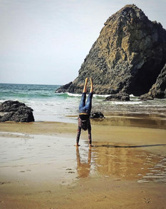 girl doing hand stand on a beautiful beach morning 