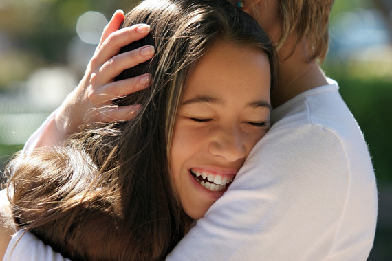 child smiling in parent's arms.