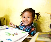 Young child smiling and drawing