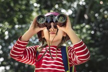 child outside holding binoculars