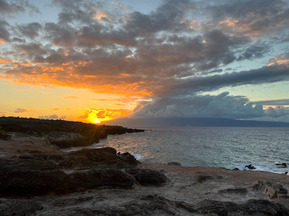 photo of a hawaiin beach with clouds and a sunset off to the left side