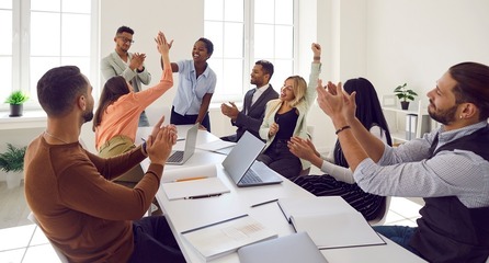 Work group of professionals clapping, high-fiving colleague; recognition. 