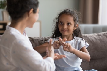 girl using asl with adult