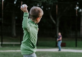 kids throwing baseball to a person who is far away