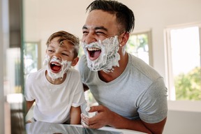 dad and son with shaving cream on their face, smiling