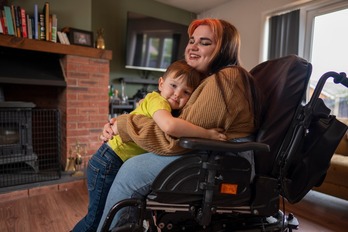 Woman on wheelchair hugging son