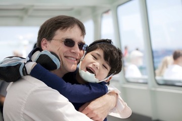 Man with glasses holds child.