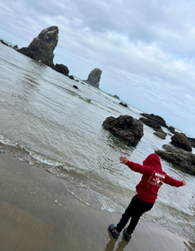 boy looking out to the water at the beach