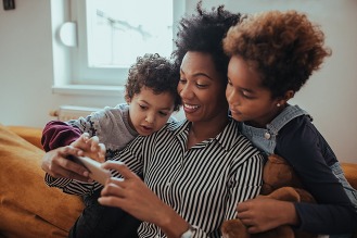 Kids show their mom how to use smart phone