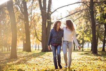 senior woman having a walk through foliage with daughter