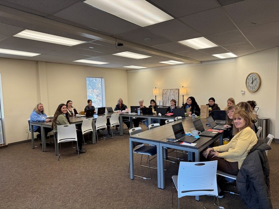Group photo of the SPARC staff in a meeting room, smiling and sitting around a U-shaped table configuration.