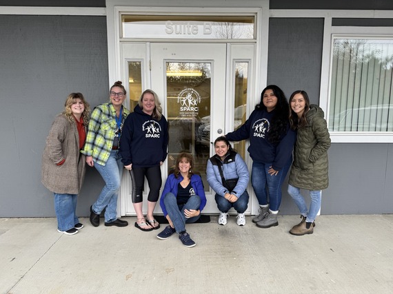 Group photo of the SPARC Family Resource Coordinators, smiling and standing in front of SPARC facilities. 
