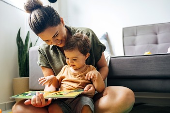 mom and son reading a book on the floor