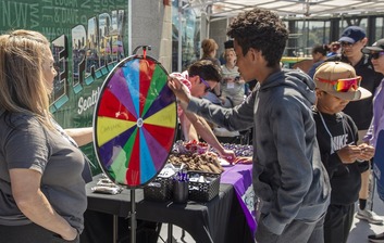 kid spinning a prize wheel at We Are Family Day 