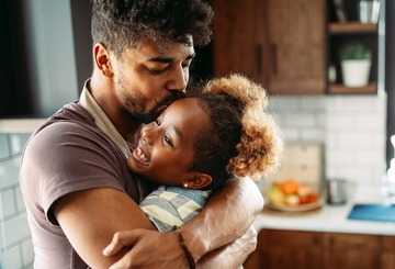 dad and daughter hugging in the kitchen