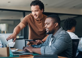 Teamwork makes everything easier. Shot of two young businessmen working together in an office.