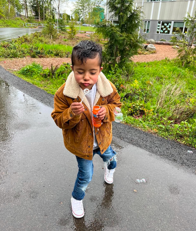 boy blowing bubbles outside 