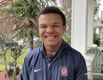 teen smiling big at the camera trees in the background